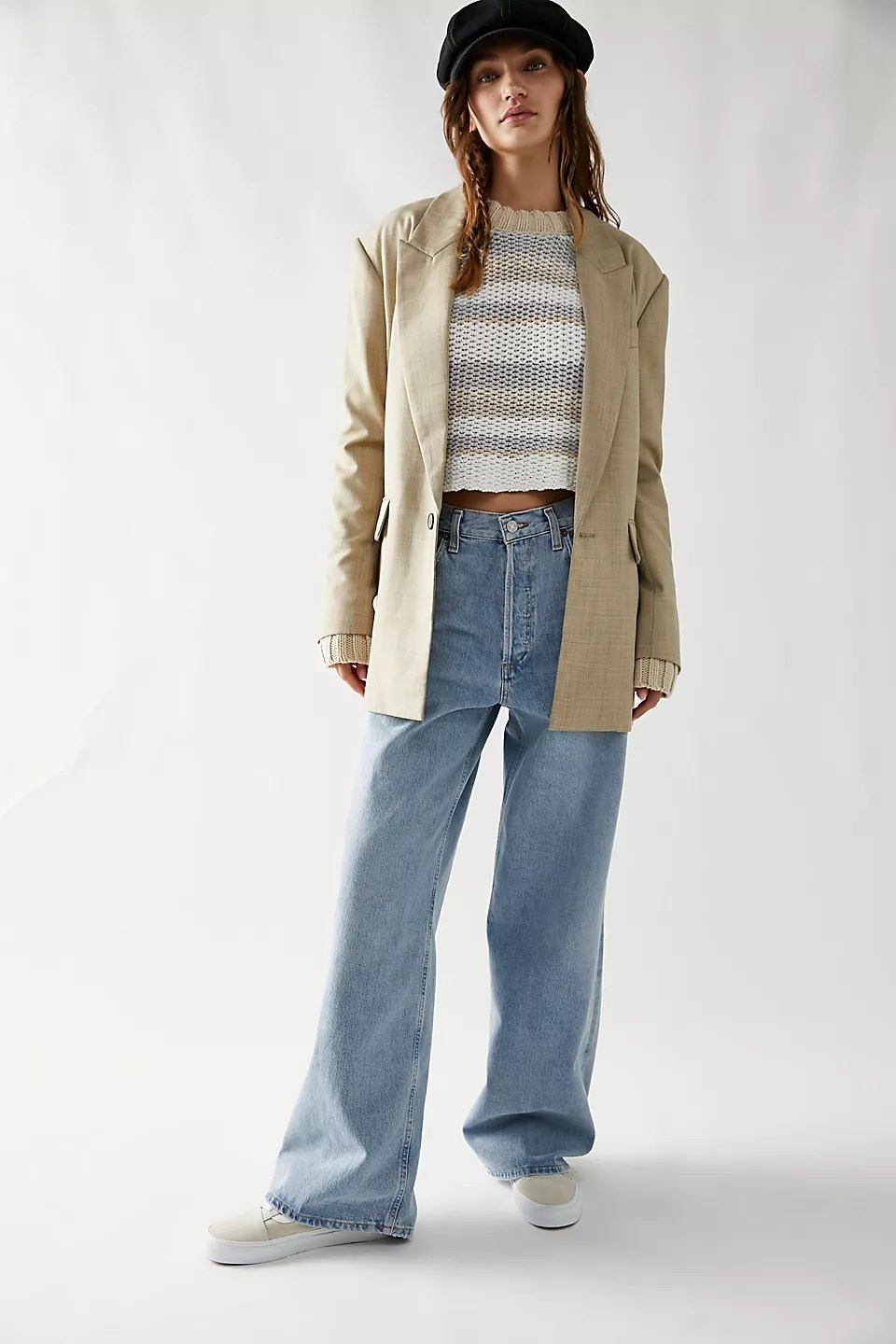 agolde low rise baggy jeans on a model wearing a knit sweater and a blazer