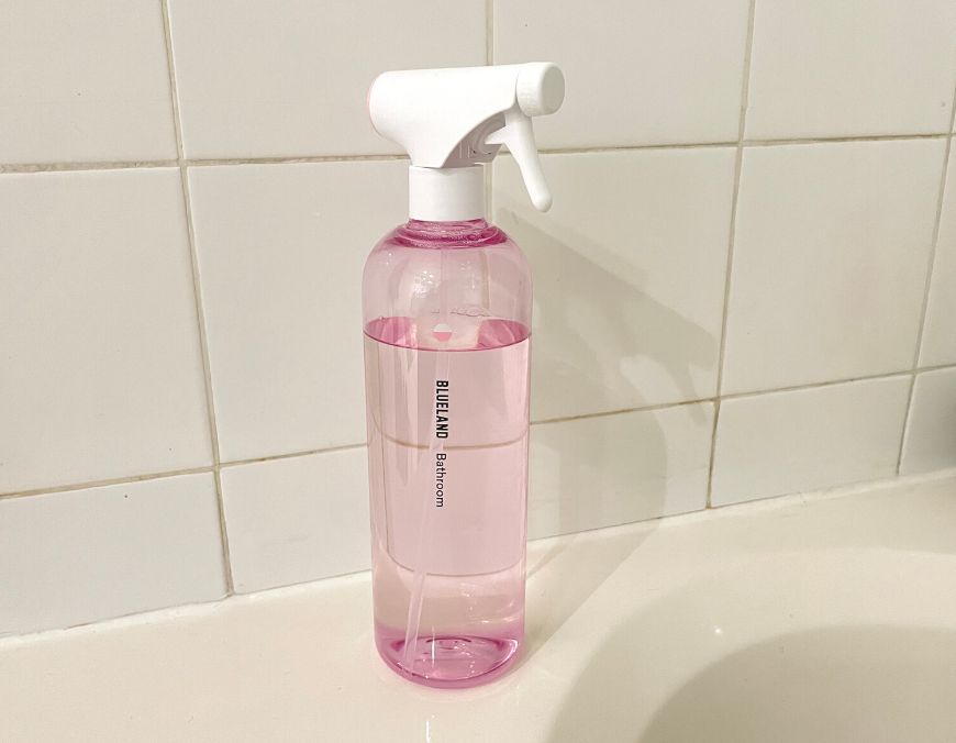blueland bathroom cleaning spray on the edge of a bathtub