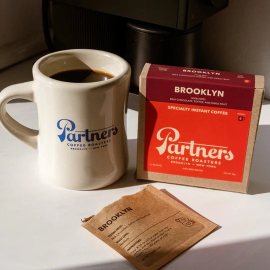 partners brooklyn instant coffee next to coffee mug and sachet