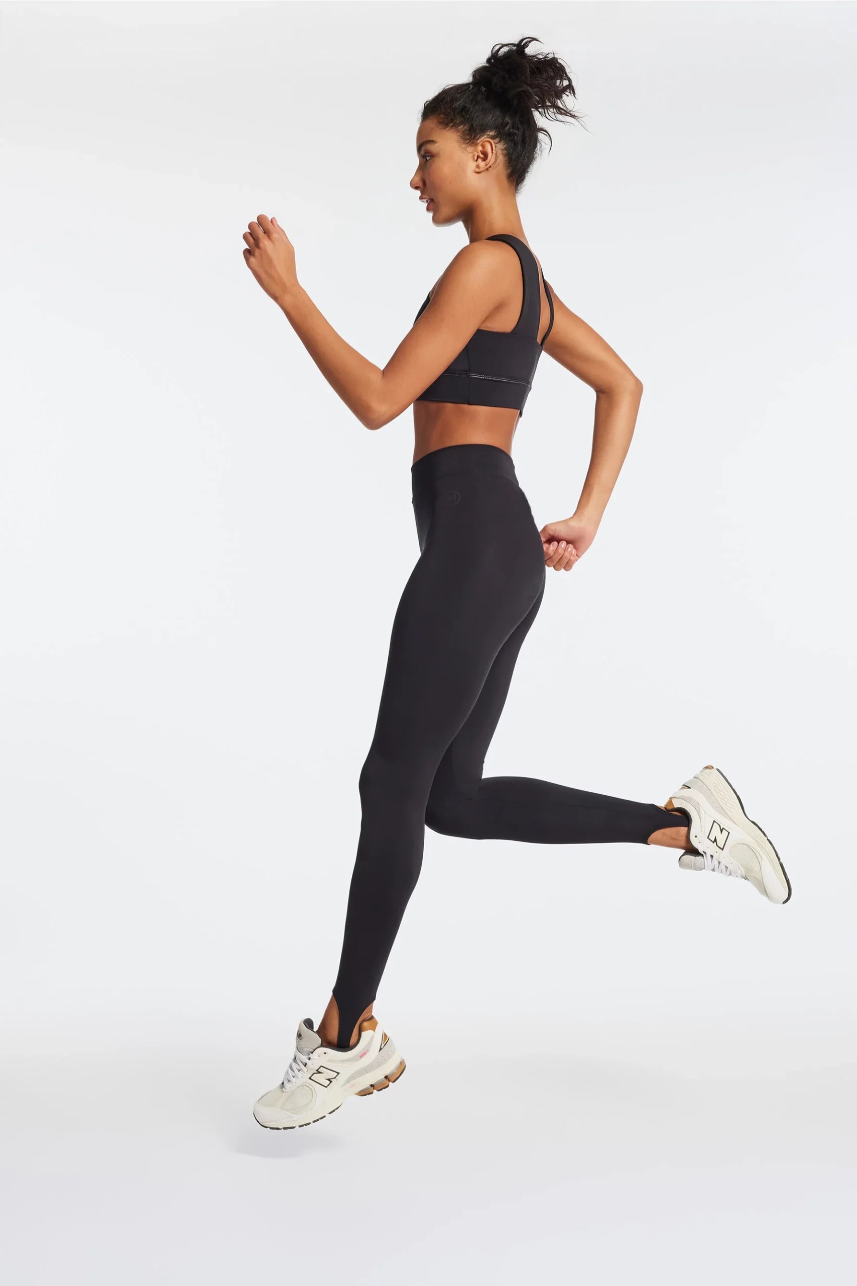 bandier stirrup leggings on a model jogging in place