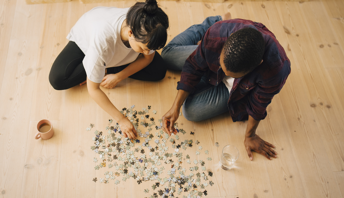 couple doing a wooden jigsaw puzzle for adults on the floor