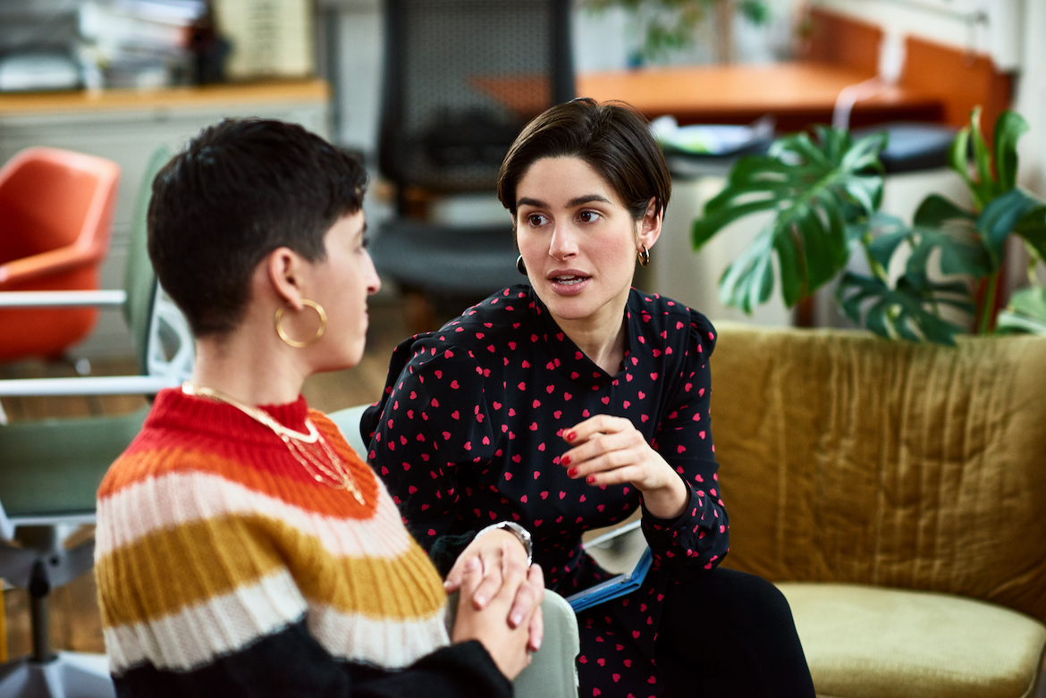 Female coworkers discuss ideas during break from meeting, sharing, listening, moving forward