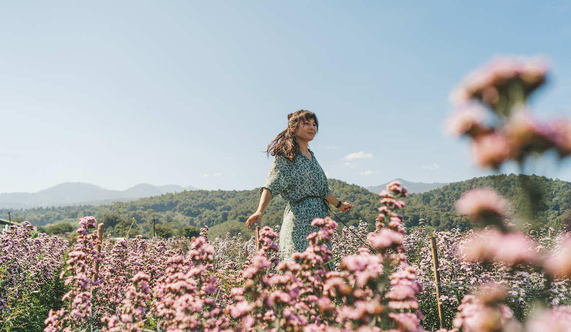 woman standing in field of flowers