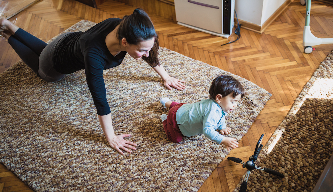 Woman at home exercising with her baby.