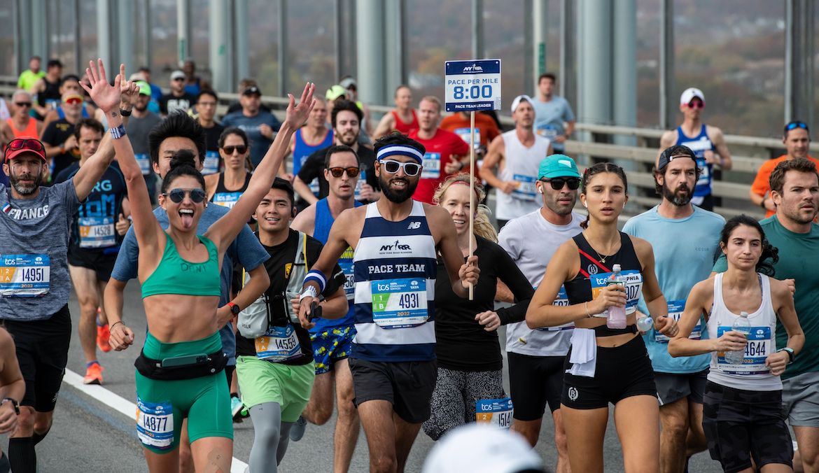 A pacer leads a group of runners in the NYC Marathon with strategic marathon pacing