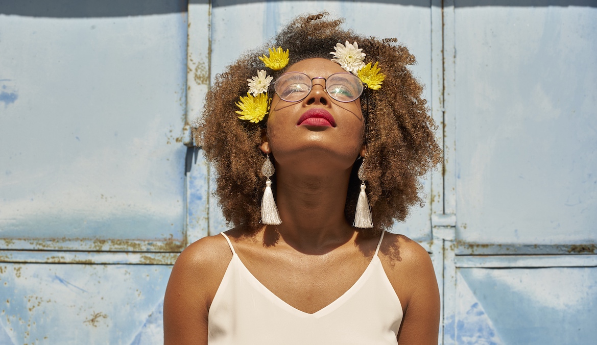 woman looking to the sun with flowers in her hair
