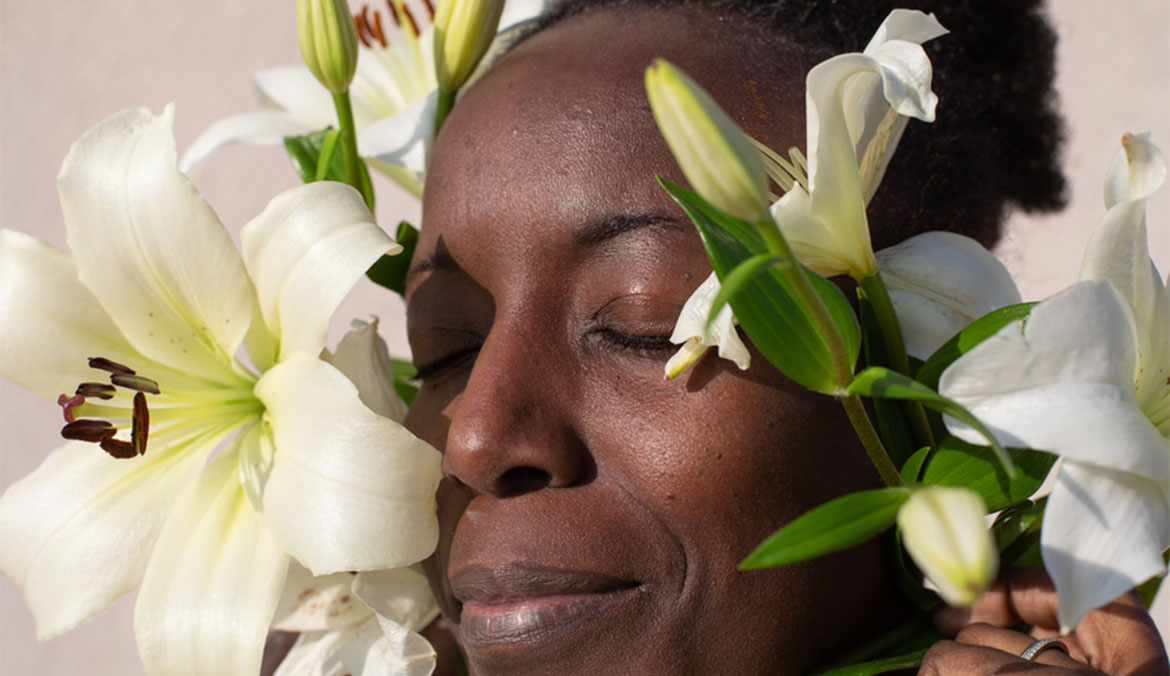 A woman posing with white lilies.