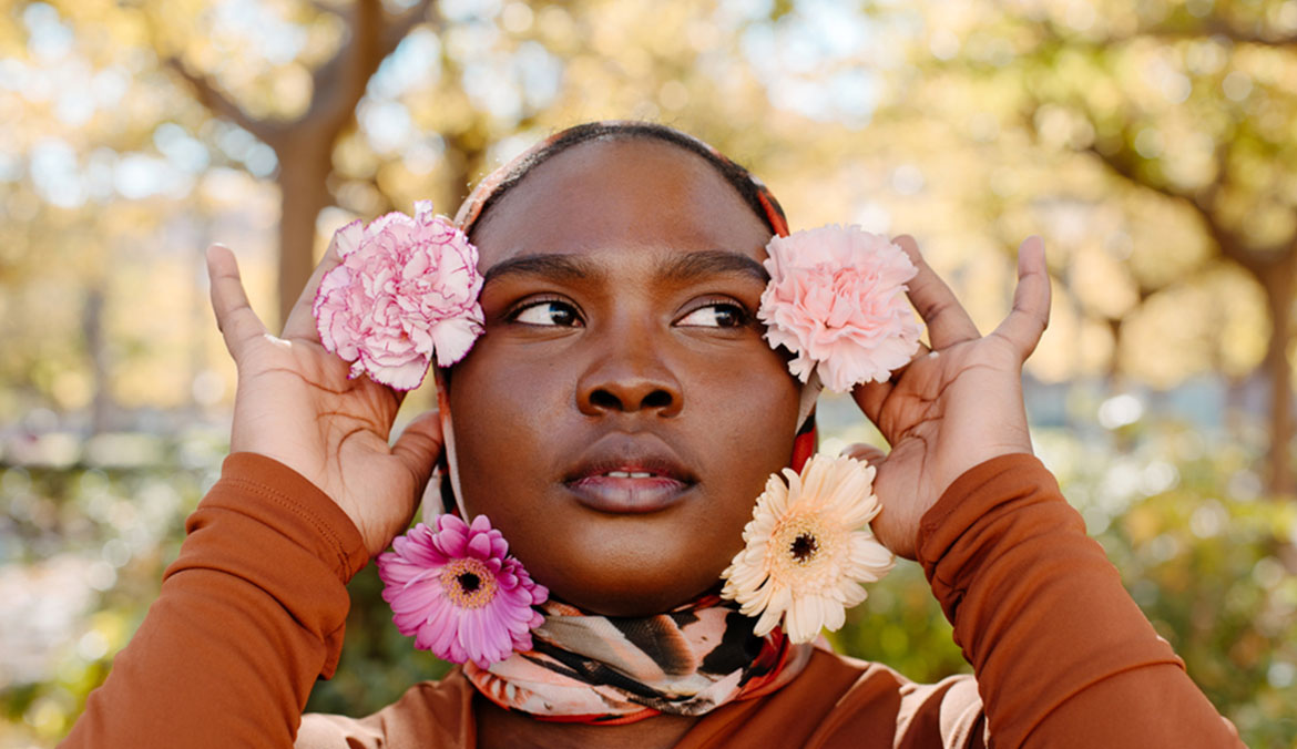 Black muslim woman with flowers on her hijab.