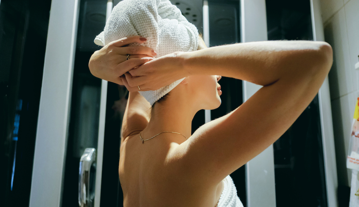 Woman drying her hair with towel in bathroom