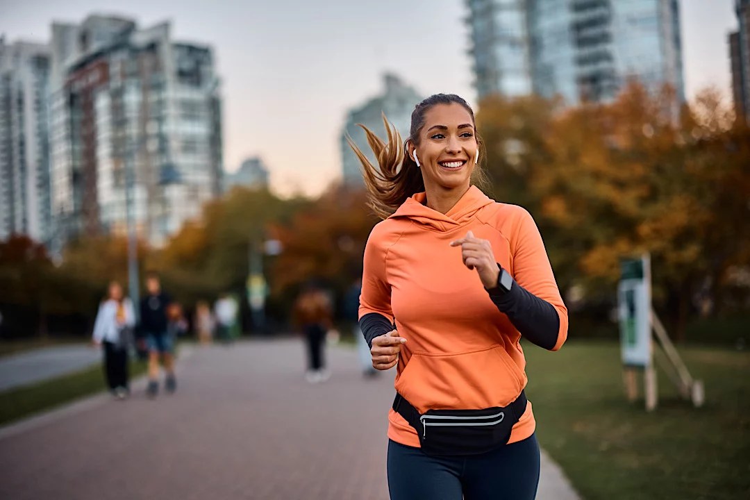 Woman smiling running outside.