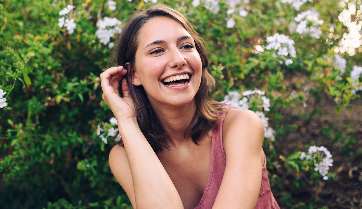 Portrait of a beautiful young woman laughing in a natural setting