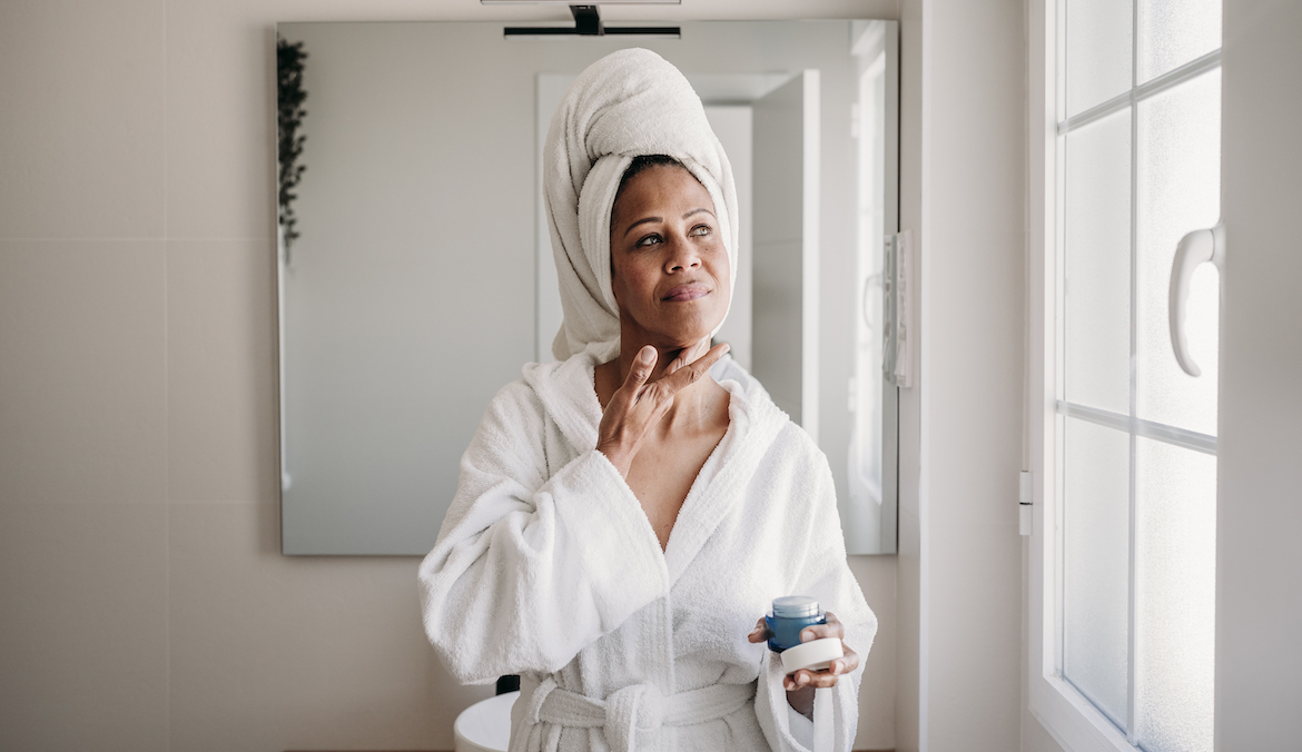 woman applying avène lipid-replenishing balm to her face and neck