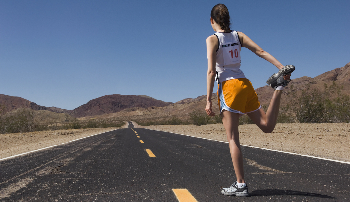 woman runner stretching in front of desert