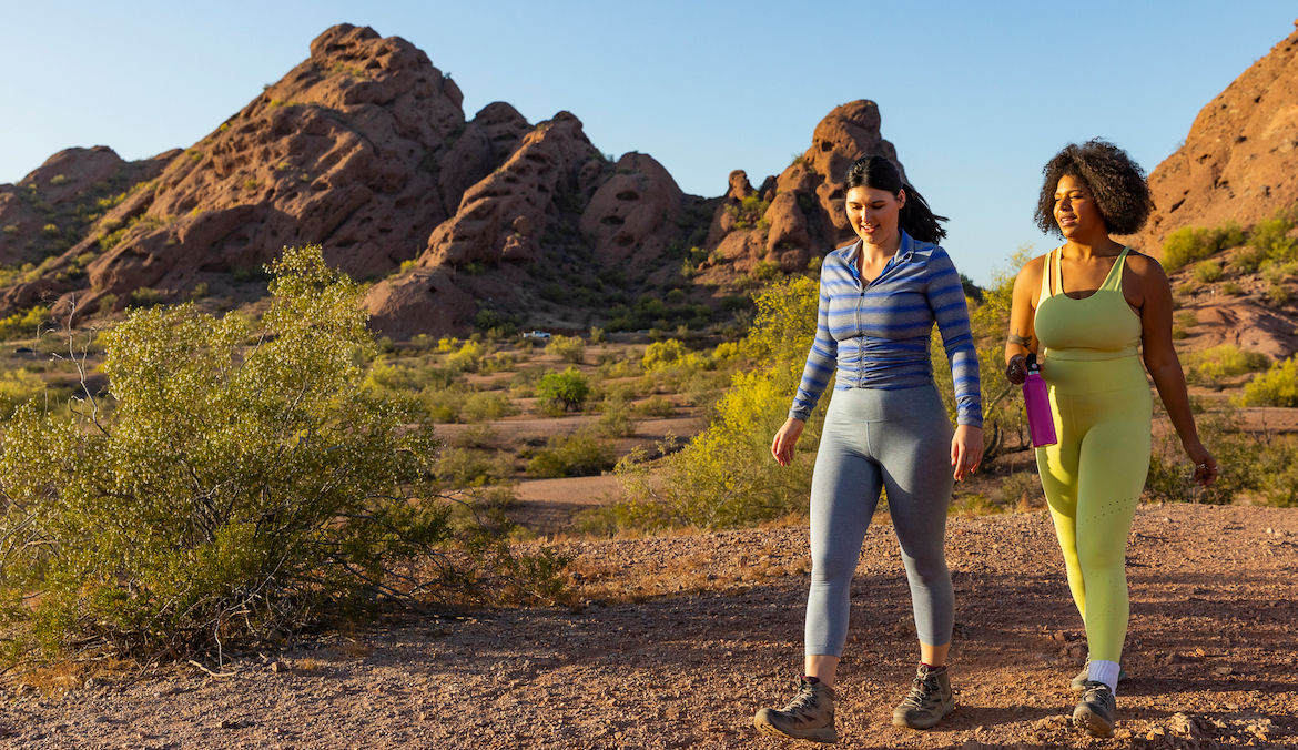 Two women hiking in a desert landscape.