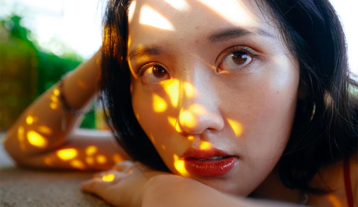 A woman with yellow light reflecting on her face.