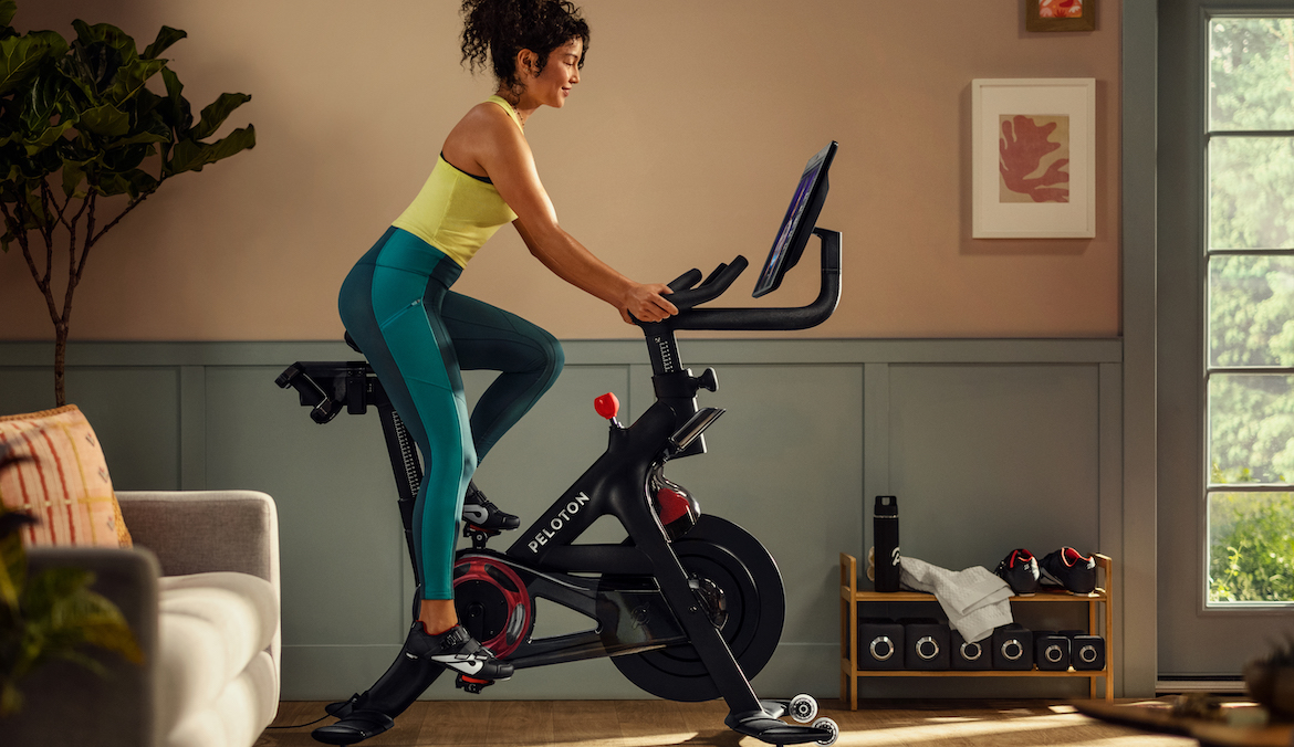 A woman seen in profile riding a stationary exercise bike.