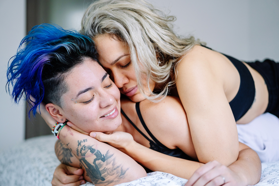 Lesbian couple cuddling in bed