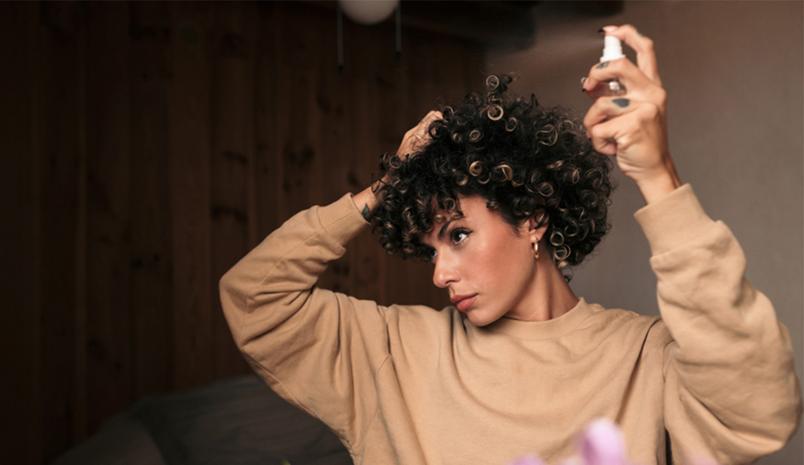 Woman spraying her hair