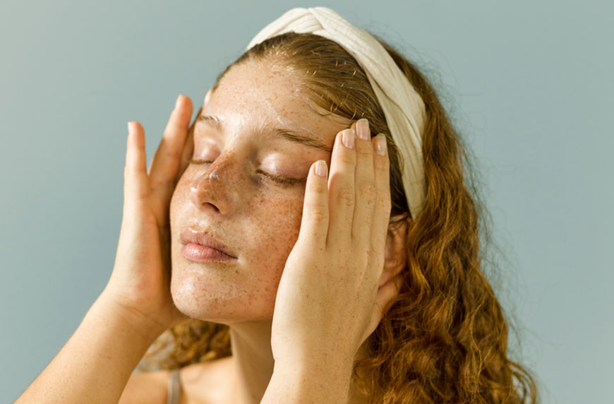 Woman practicing facial massage techniques