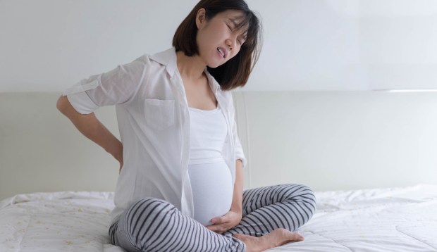Here’s Why Your Back Might Hurt During Pregnancy, and What To Do About It