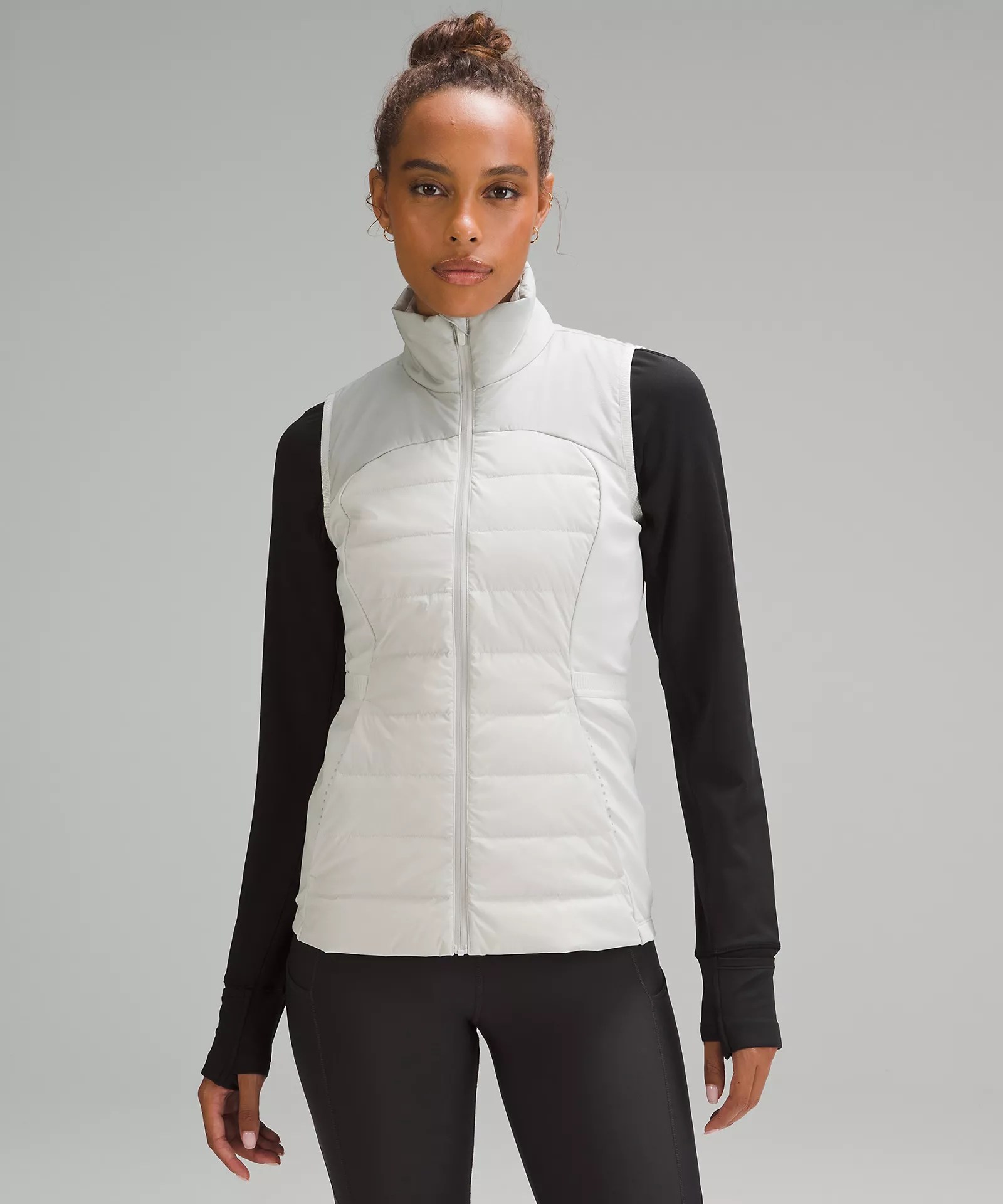 a woman wearing a white lululemon down for it all vest, one of the best luluemon products