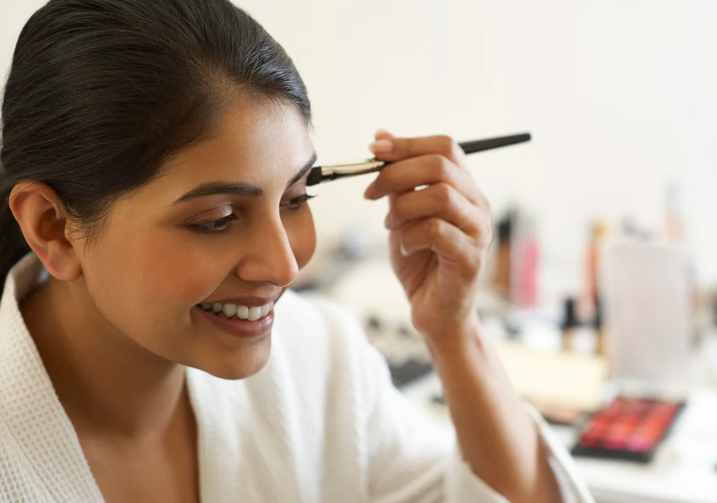 Woman applying eye makeup after using the best eyeshadow primer