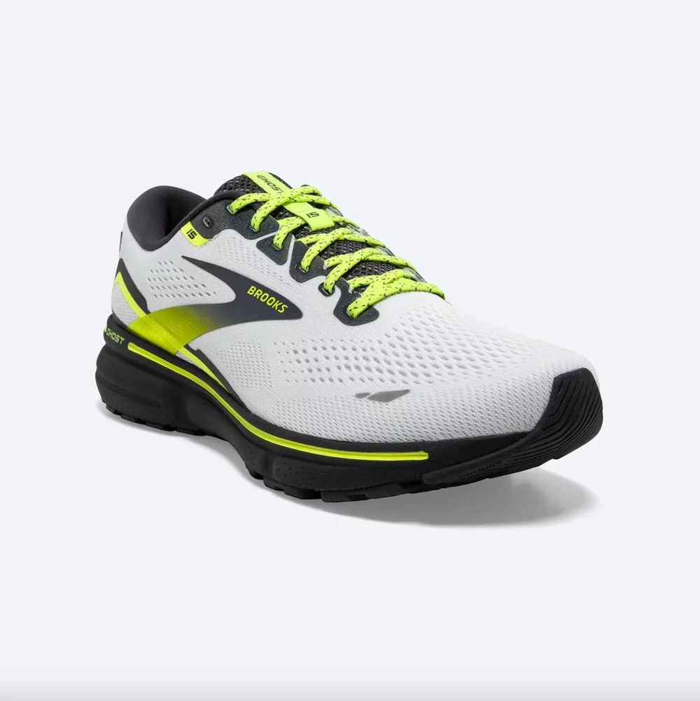 A pair of white running shoes with neon yellow and black accents.
