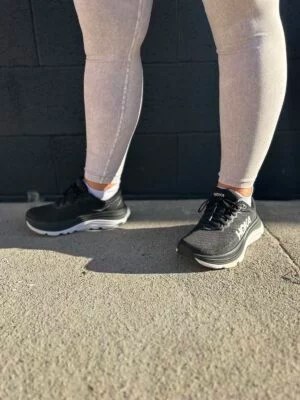 A sneaker close up on a woman wearing black running shoes.