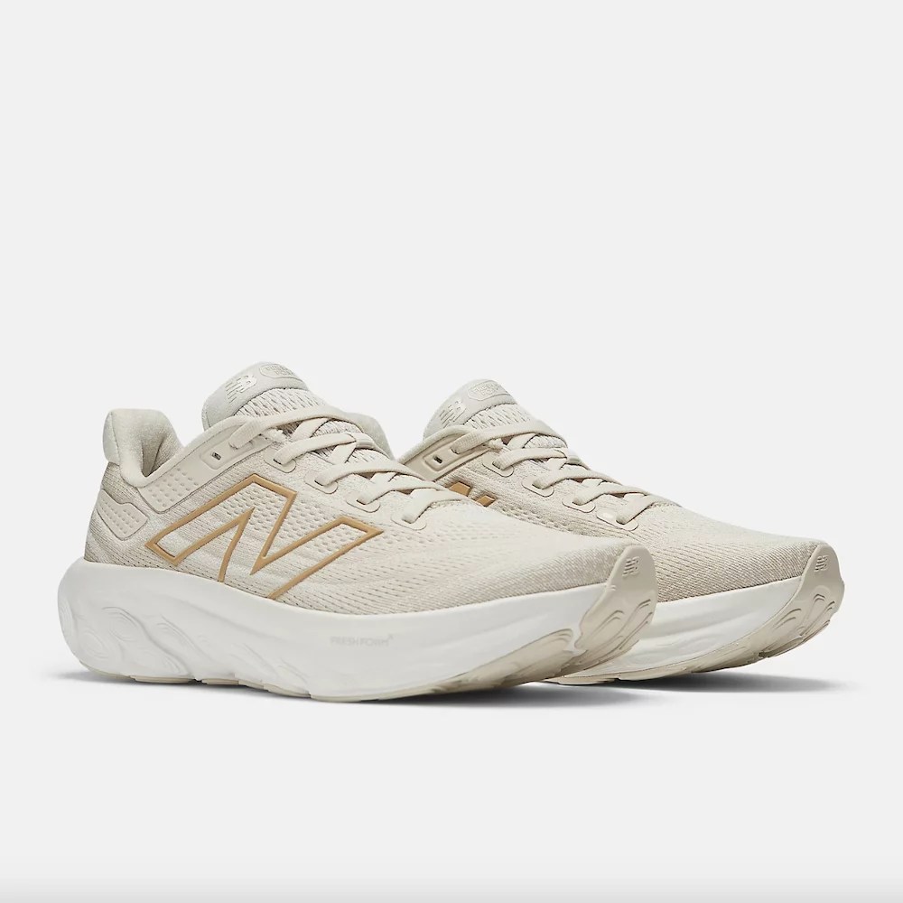 A pair of beige running shoes with white and gold accents.
