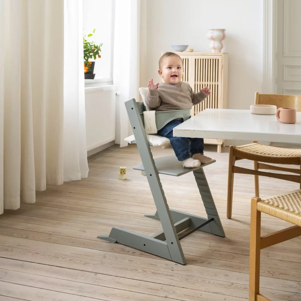 A baby in a minimalist modern looking high chair is one of the maternity and baby black friday deals on Babylist.
