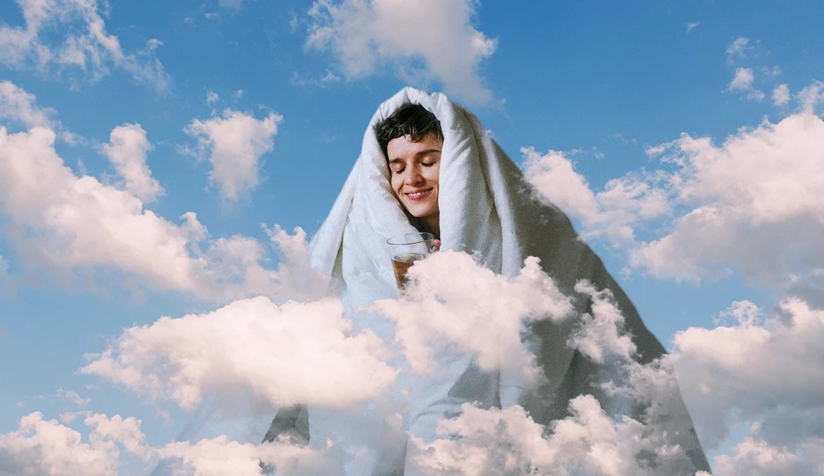 woman wrapped in soft clothes and comforter surrounded by clouds