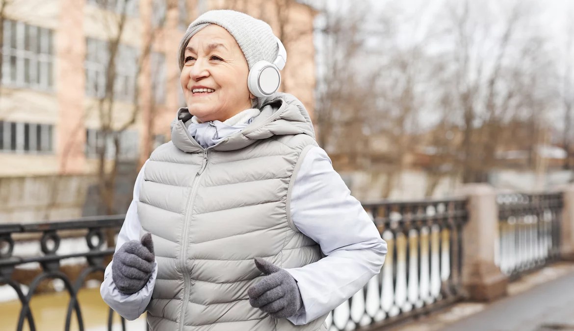 A senior woman power walking in winter clothes.