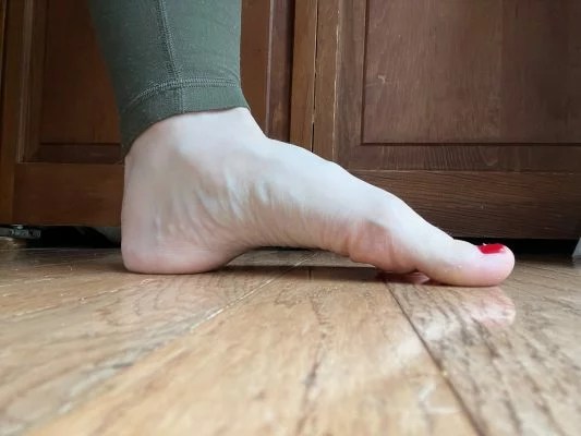 Nahaufnahme des Fußes einer Frau, die zeigt, wie man die Plantarfasziitis-Übung „Doming“ durchführt