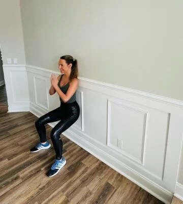 Physical therapist demonstrating wall squat 