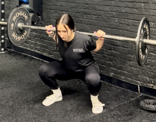 Physical therapist demonstrating barbell back squat