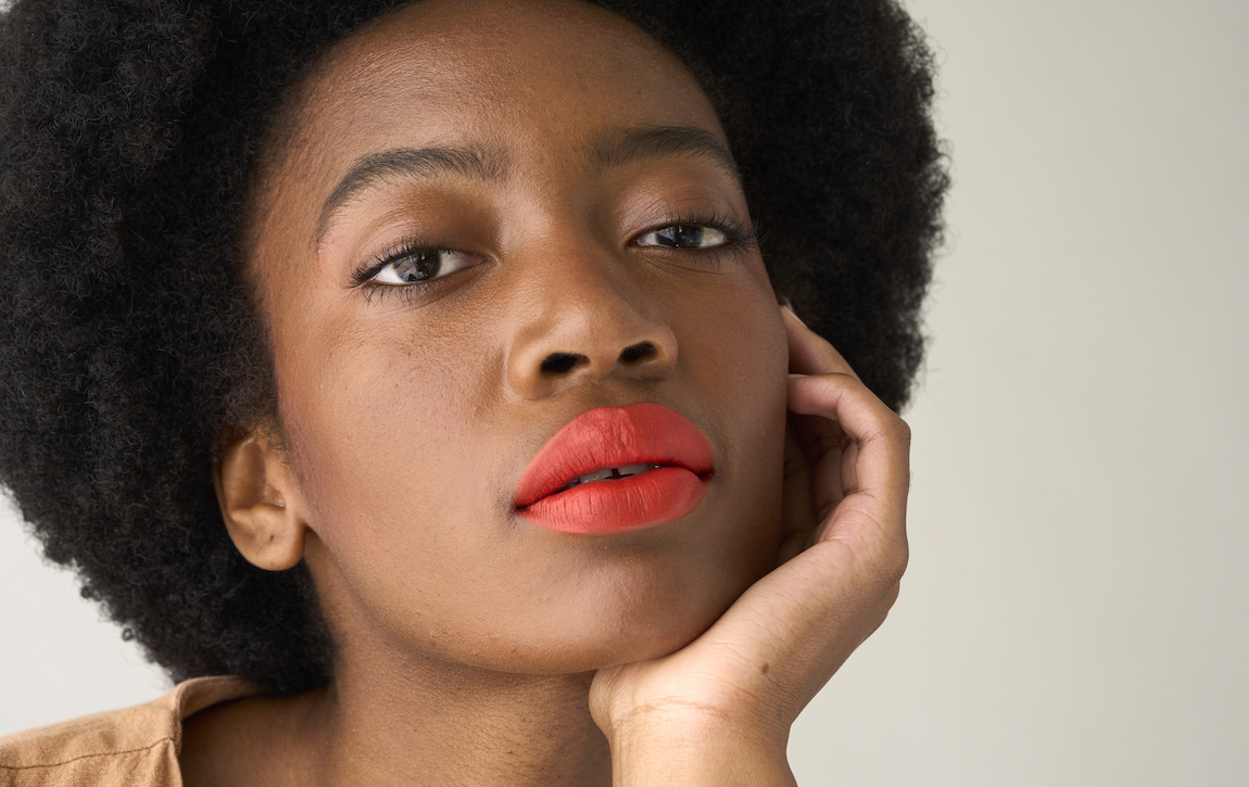 A woman wearing red matte lipstick.