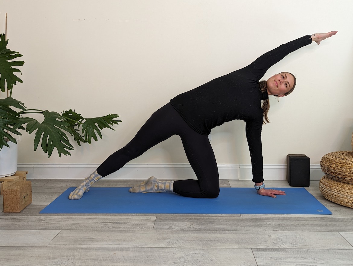 Yoga teacher demonstrating side plank modification