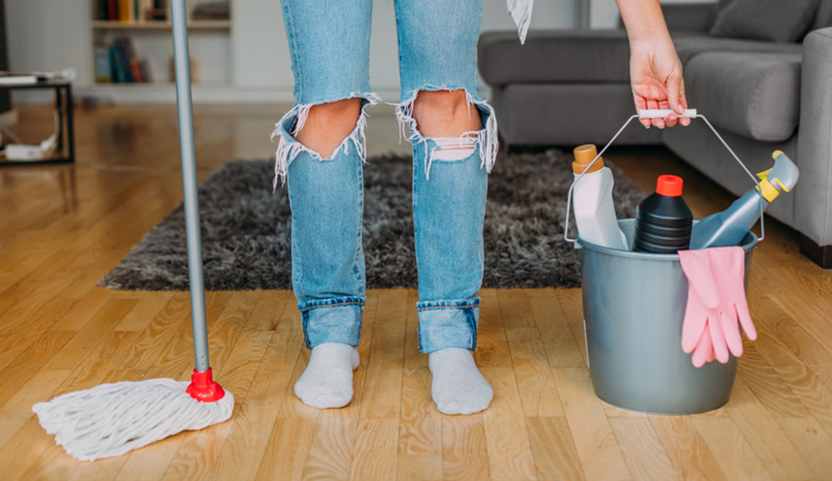 woman holds cleaning materials like a mop and bucket before learning how to use steam cleaner