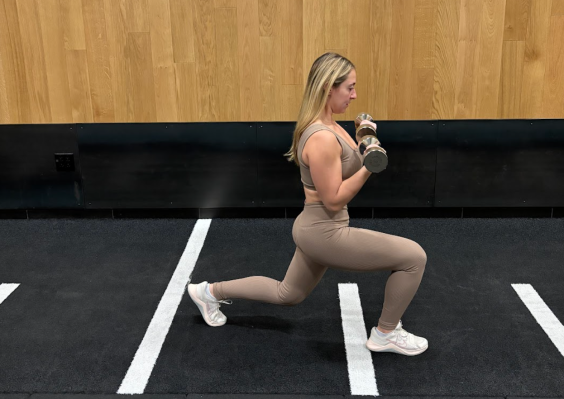 Personal trainer demonstrating reverse lunge with biceps curl