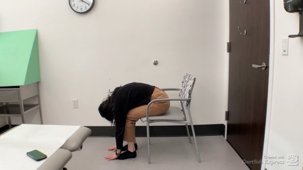 Physical therapist demonstrating seated forward bend