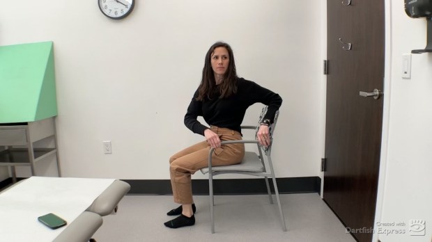 Physical therapist demonstrating seated mid-back rotation