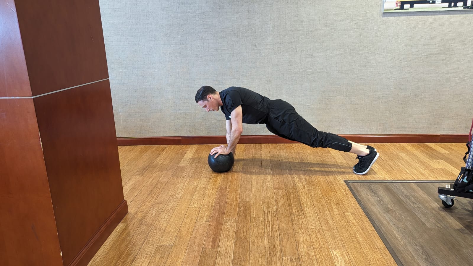 personal trainer does alternating push-ups on top of a heavy ball at the gym
