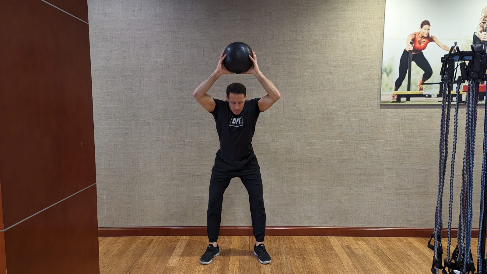 fit personal trainer does an overhead slam ball exercise