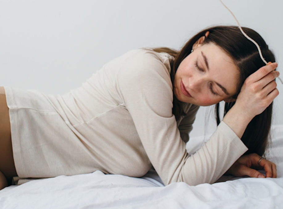woman laying in bed looking relaxed for a personal essay on acupuncture for mental health