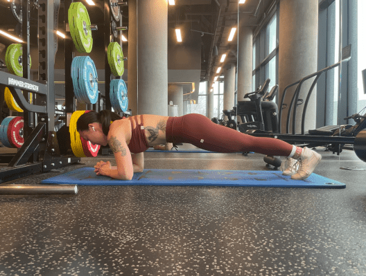 Personal trainer demonstrating a forearm plank