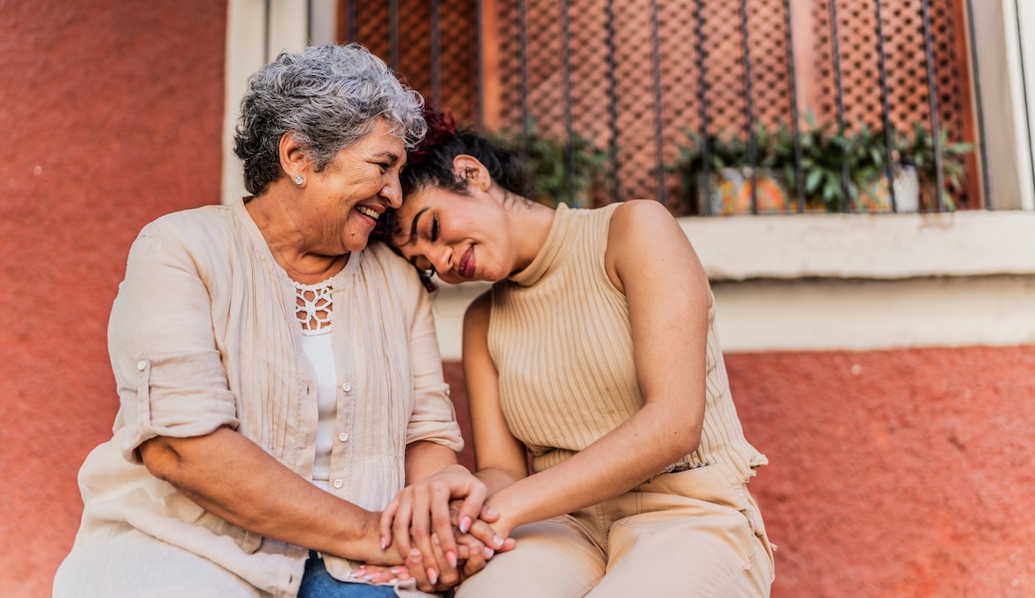 older woman embracing younger woman while smiling