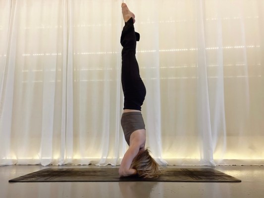 Yoga teacher demonstrating headstand