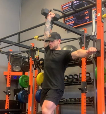 Personal trainer demonstrating single-arm dumbbell overhead press