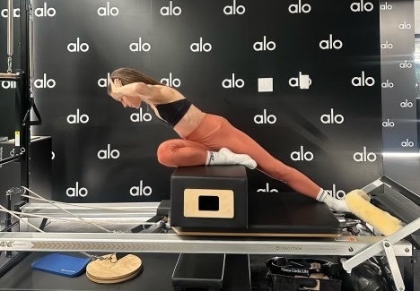 Pilates trainer demonstrates the mermaid with a twist, one of the most effective pilates moves for your core