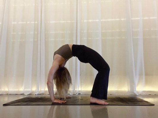 Yoga teacher demonstrating wheel pose
